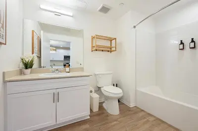 a white bathroom with a toilet and a sink at NEW LUX Modern Retreat Views Parking Workspaces in San Diego