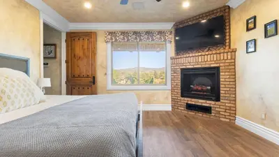 a bedroom with a fireplace and a bed and a television at 2 Homes in Bella Vista Rd by AvantStay Sleeps 8 Vineyard Views Patios in Temecula Wine Trail in Temecula