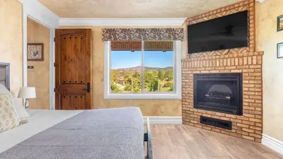 a bedroom with a fireplace and a flat screen tv at New-Build Temecula Villa with King Suite Patio Vineyard Views The Villa by AvantStay in Temecula