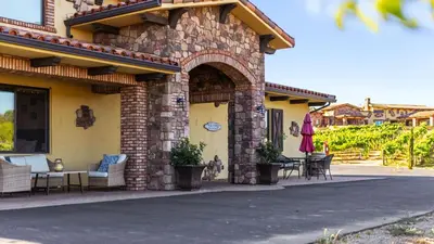 a stone house with chairs and tables on a street at New-Build Temecula Villa with King Suite Patio Vineyard Views The Villa by AvantStay in Temecula