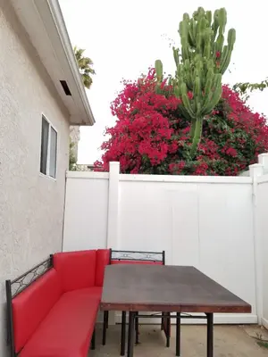 a red couch and a table in front of a fence at The Hideaway in San Diego
