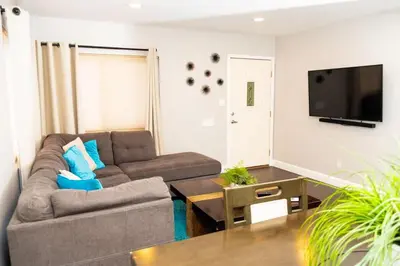 a living room with a couch and a tv at Sutra in San Diego