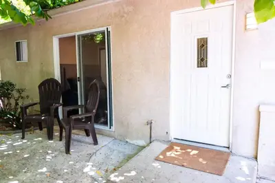 a porch with two chairs and a white door at Sutra in San Diego
