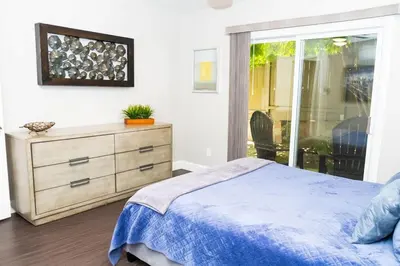 a bedroom with a bed and a dresser and a window at Sutra in San Diego