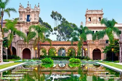 an ornate building with a pond and palm trees at Sutra in San Diego
