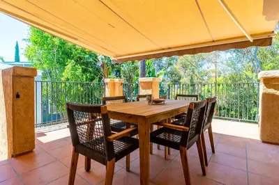 a wooden table and chairs under an umbrella on a patio at Canyon Treehouse in San Diego
