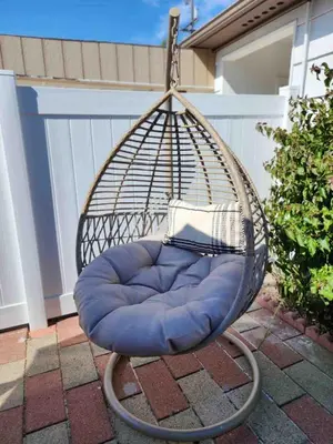 a swing chair with a blue cushion on a patio at Allure Retreat in San Diego