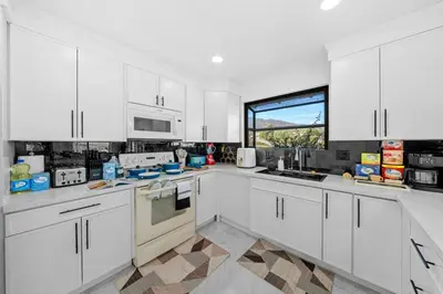 a kitchen with white cabinets and a large window at Entire Private Home with 3 Bedrooms 2 Bathrooms, Mountain View, Jetted Tub, 2500 sqft, King Bed,Garage, Available Now in Jamul