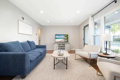 a living room with a blue couch and two chairs at Central Backyard Oasis Villa in San Diego