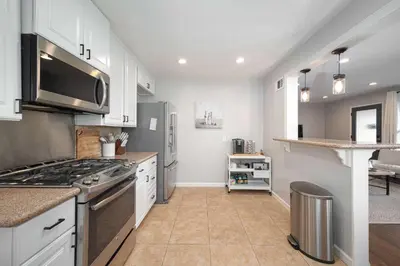 a kitchen with white cabinets and a stove top oven at Central Backyard Oasis Villa in San Diego