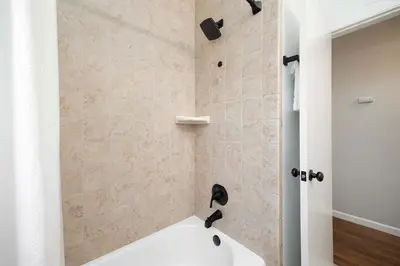 a bathroom with a shower with a white tub at Central Backyard Oasis Villa in San Diego