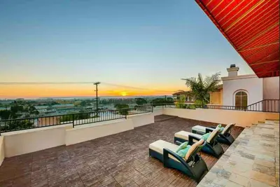 a balcony with couches and a sunset in the background at Stunning Views, Rooftop Vista, Pool & Spa in San Diego
