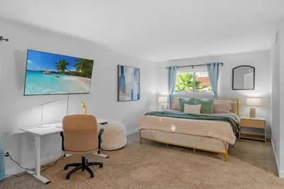 a bedroom with a bed and a desk and a window at Entire Private Home with 3 Bedrooms, Hot Tub, King Bed, Garage, Grand View, Available Now in San Diego
