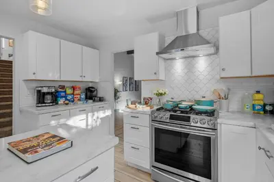 a kitchen with white cabinets and a stove top oven at Entire Private Home with 3 Bedrooms, Hot Tub, King Bed, Garage, Grand View, Available Now in San Diego