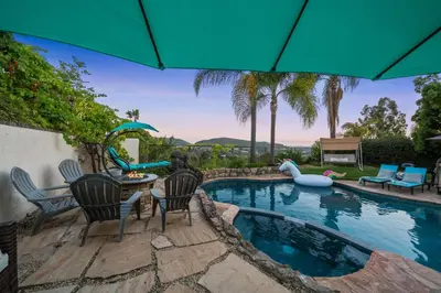 a swimming pool with a table and chairs and an umbrella at Entire Private Home with 3 Bedrooms, Hot Tub, King Bed, Garage, Grand View, Available Now in San Diego