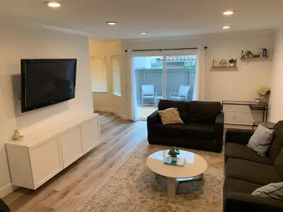 a living room with a flat screen tv on a wall at Beautifully Remodeled 2BR Prime Irvine Location in Irvine