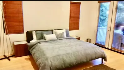 a bedroom with a bed and two windows at Quail Hill Condo in Irvine