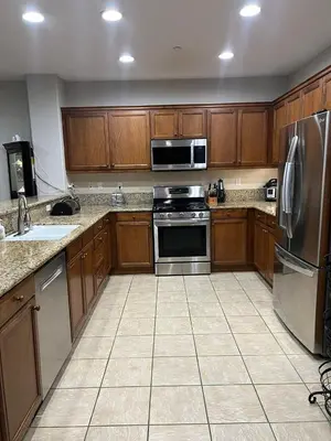 a kitchen with wooden cabinets and stainless steel appliances at Quail Hill Condo in Irvine