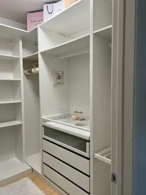 a white walk in closet with white cabinets at Quail Hill Condo in Irvine