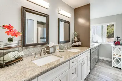 a bathroom with two sinks and two mirrors at Pool Access and Private Deck Mtn-View Bonita Studio in Bonita