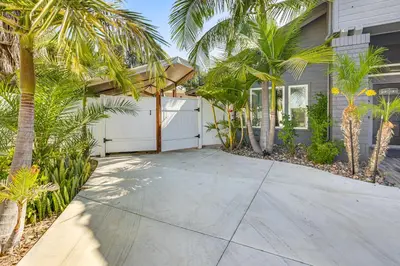 a driveway with palm trees in front of a house at Pool Access and Private Deck Mtn-View Bonita Studio in Bonita
