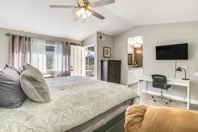 a bedroom with a bed with a ceiling fan and a desk at Pool Access and Private Deck Mtn-View Bonita Studio in Bonita