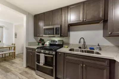 a kitchen with brown cabinets and a stove and a sink at Central San Diego 2 BED Condo in San Diego