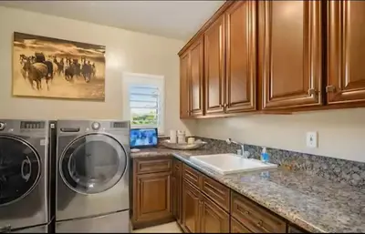 a kitchen with a washing machine and a sink at Luxury Estate Tucked Away in the Exclusive Area of Tenaja in Murrieta