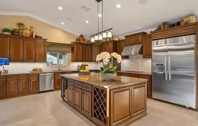 a large kitchen with wooden cabinets and stainless steel appliances at Luxury Estate Tucked Away in the Exclusive Area of Tenaja in Murrieta