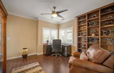 a living room with a ceiling fan and a desk at Luxury Estate Tucked Away in the Exclusive Area of Tenaja in Murrieta