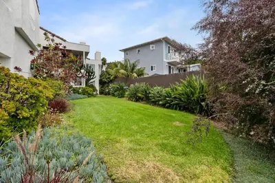 a yard with green grass and a house at New Cozy Leucadia Beach House with parking in Encinitas