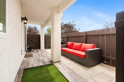 a patio with a red couch on a fence at New Cozy Leucadia Beach House with parking in Encinitas