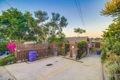 a house with a fence and a driveway at 3BRB with Bonus Bedroom, Hot Tub, Tropical Oasis in San Diego