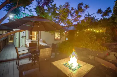 a patio with a table and an umbrella and a fire pit at 3BRB with Bonus Bedroom, Hot Tub, Tropical Oasis in San Diego