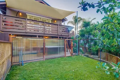 a house with a fence in front of a yard at 3BRB with Bonus Bedroom, Hot Tub, Tropical Oasis in San Diego
