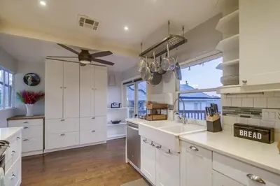 a kitchen with white cabinets and a large window at 3BRB with Bonus Bedroom, Hot Tub, Tropical Oasis in San Diego