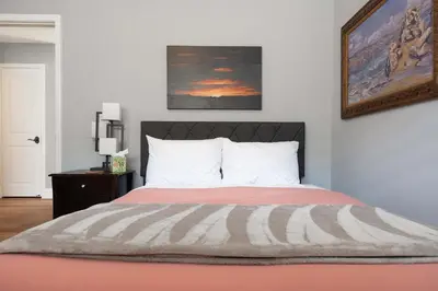 a bedroom with a bed and a painting on the wall at Prime Location Spacious townhome in San Diego