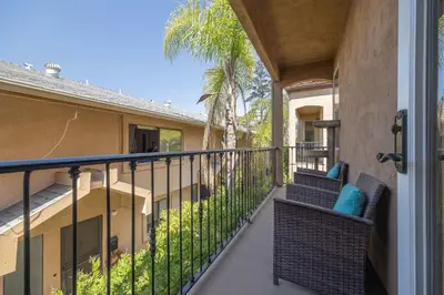 a balcony of a home with two chairs and palm trees at Prime Location Spacious townhome in San Diego