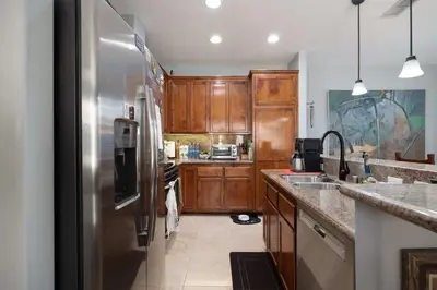 a kitchen with wooden cabinets and a stainless steel refrigerator at Prime Location Spacious townhome in San Diego