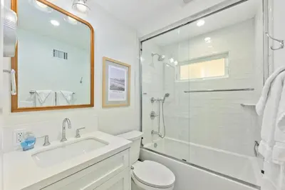 a white bathroom with a sink and a shower at Sail & Sea in Newport Beach
