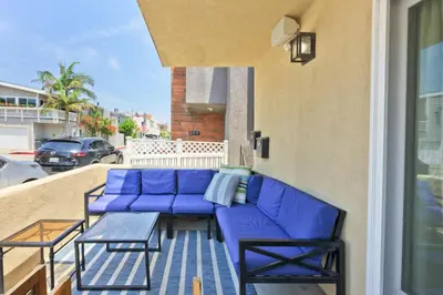 a patio with blue furniture on a balcony at Sail & Sea in Newport Beach