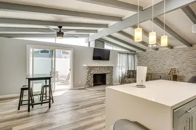 a living room with a table and a fireplace at 6 Mi to Pacific Beach Pet-Friendly San Diego Home in San Diego