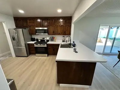a kitchen with wooden cabinets and a white counter top at Family Fun Getaway - 3BR - Games - BBQ Patio in Santee