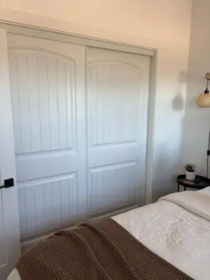 a bedroom with a white closet door next to a bed at The Hilltop Haven - Romantic Getaway Suite in Temecula