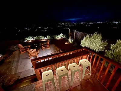 a deck with four chairs and a table at night at The Hilltop Haven - Romantic Getaway Suite in Temecula