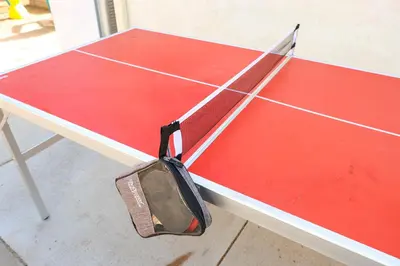 a ping pong racket sitting on top of a tennis court at Cozy Chic Casa ,Spa ,Ac ,Theatre , Downtown, Beach in La Mesa