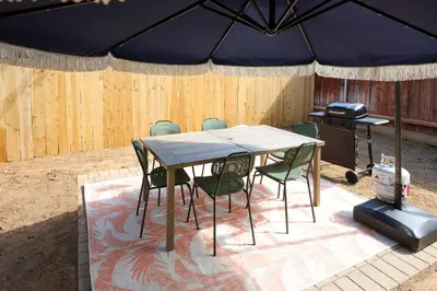 a table and chairs under a large umbrella at Cozy Chic Casa ,Spa ,Ac ,Theatre , Downtown, Beach in La Mesa
