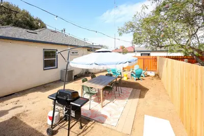 a patio with a table and an umbrella at Cozy Chic Casa ,Spa ,Ac ,Theatre , Downtown, Beach in La Mesa