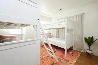 a white bunk bed in a white room at Cozy Chic Casa ,Spa ,Ac ,Theatre , Downtown, Beach in La Mesa