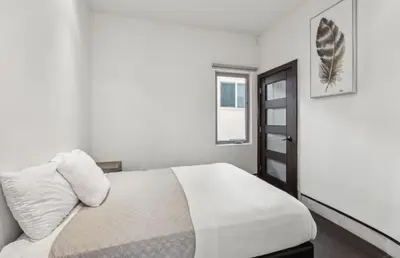 a white bedroom with a bed and a window at The Wave House! Custom Gem with Panoramic Views, Fire Pit, BBQ, Pool Table in San Diego